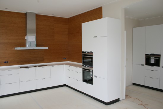 Witte moderne keuken met houten achterwand - Arnhem